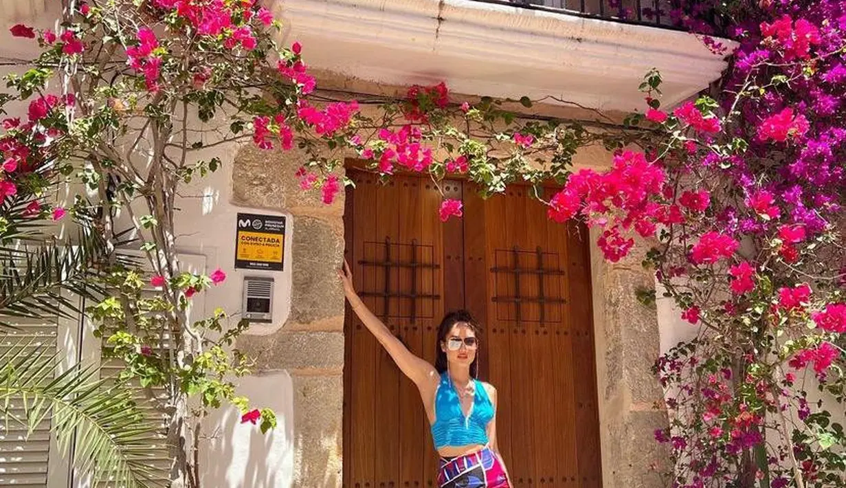 Bak barbie hidup, Cinta Laura tampil menawan memadukan crop tank top warna biru dengan mini skirt bermotif colorful saat liburan. (Instagram/claurakiehl).