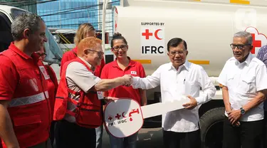 Ketua Umum PMI, Jusuf Kalla secara simbolis menerima kendaraan bantuan dari Kepala IFRC Perwakilan Indonesia-Timor Leste dan ASEAN, Jan Gelfand di Markas PMI Pusat, Jumat (17/1/2020). IFRC menyerahkan bantuan berupa 10 unit truk tangki air dan satu truk barang. (Liputan6.com/Herman Zakharia)