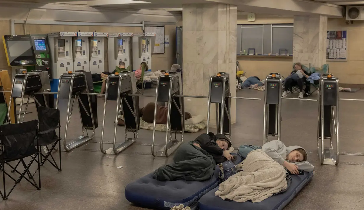 Orang-orang berlindung di stasiun metro selama serangan udara Rusia di Kyiv pada 21 Agustus 2025, di tengah invasi Rusia ke Ukraina. (Roman PILIPEY/AFP)