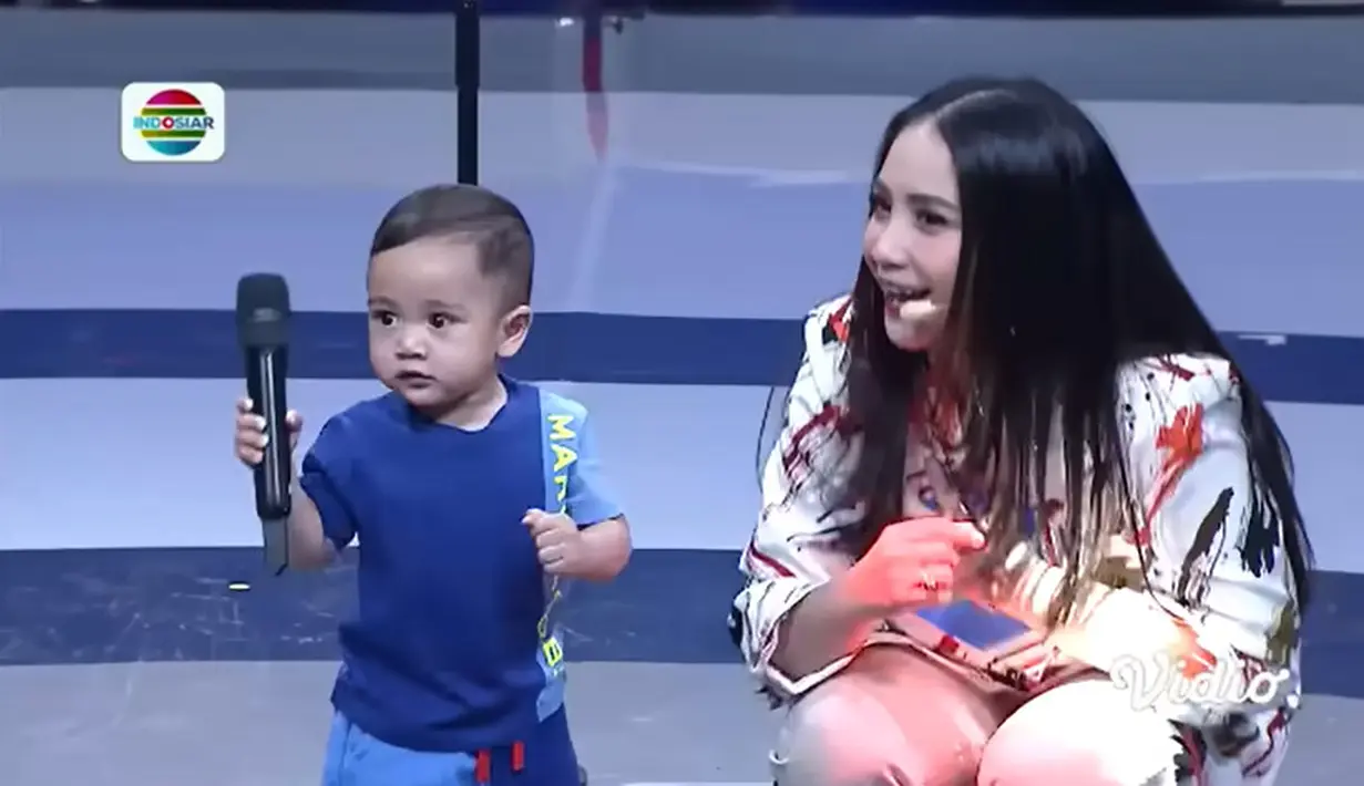 Nagita memberikan mik pada putranya. Rayyanza pun tampak asyik sambil mengoyangkan tubuhnya sambil memegang miknya. [Youtube/Indosiar]