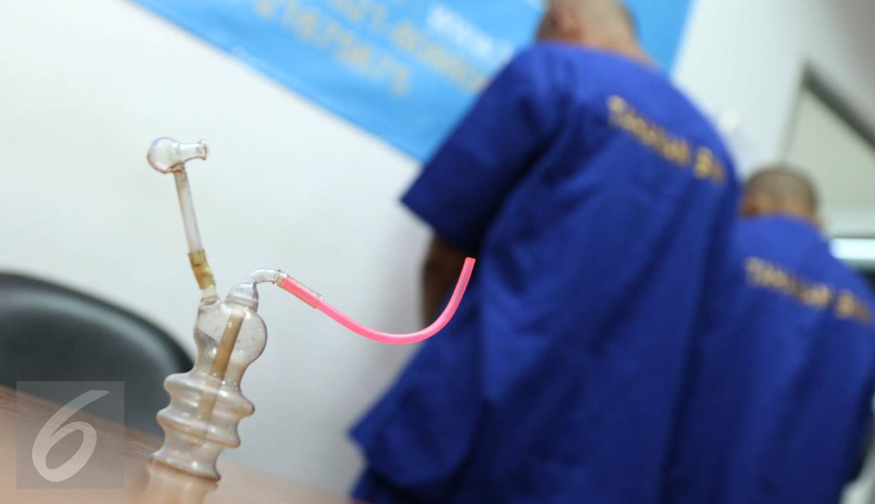 Petugas BNN menunjukkan dua tersangka berinisial H dan TS di kantor BNN Kota Jakarta Utara, Selasa (15/11). BNN Kota Jakarta Utara berhasil mengamankan barang bukti berupa sabu seberat 15,12 gram serta 50 butir ekstasi. (Liputan6.com/Immanuel Antonius)