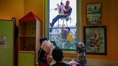 Orang-orang berpakaian seperti “Super Hero” mengantarkan telur Paskah kepada anak-anak yang dirawat di bangsal anak di klinik De Marchi, pada 28 Maret 2024 di Milan, Italia. (Piero Cruciatti/AFP)