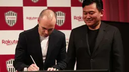 Andres Iniesta (kiri) menandatangani kontrak saat bersama Vissel Kobe di Tokyo, (24/5/2018). Andres memilih bergabung dengan Vissel Kobe selama tiga musim. (AFP/Behrouz Mehri)