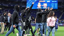 Namun, suporter dari tribun selatan Espanyol merangsek masuk lapangan, yang menyebabkan para pemain dan staf pelatih Barcelona berlari ke terowongan. (AFP/Lluis Gene)