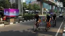 Sejumlah pesepeda melintas di samping tiang monorel yang dipasangi banner KTT ASEAN di kawasan Jalan Rasuna Said, Jakarta, Minggu (3/9/2023). Pemasangan banner pada 100 tiang monorel tersebut dilakukan guna menyambut penyelenggaraan KTT ASEAN ke-43 yang digelar pada 5-7 September 2023 di Jakarta. (Liputan6.com/Herman Zakharia)
