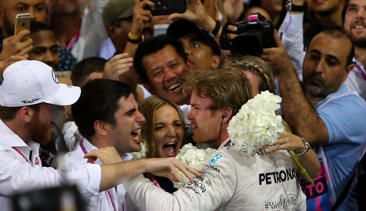 Nico Rosberg disambut anggota timnya setelah menjadi juara F1 GP Abu Dhabi yang berlangsung di Sirkuit Yas Marina, Abu Dhabi, UEA, Minggu (29/11/2015). (AFP/Marwan Naamani)
