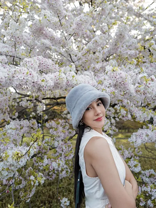 Anya sendiri tampil serasi dengan atasan berkerah tanpa lengan berwarna putih, bucket hat dari bahan bulu berwarna abu-abu, dan bawahan hitam, serta sling bag hijau. [Foto: Instagram/anyageraldine]