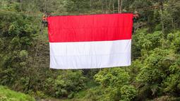 Upacara berlangsung khidmat yang ditandai dengan pengibaran bendera Merah Putih pada tali yang membentang di atas sungai di Watu Kemloso, Yogyakarta. (DEVI RAHMAN/AFP)