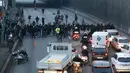 Sopir taksi memblokir jalan saat unjuk rasa menentang layanan transportasi VTC seperti Uber, di jalan lingkar di porte Maillot di Paris, Perancis, Selasa (26/1). (AFP PHOTO/Thomas SAMSON)