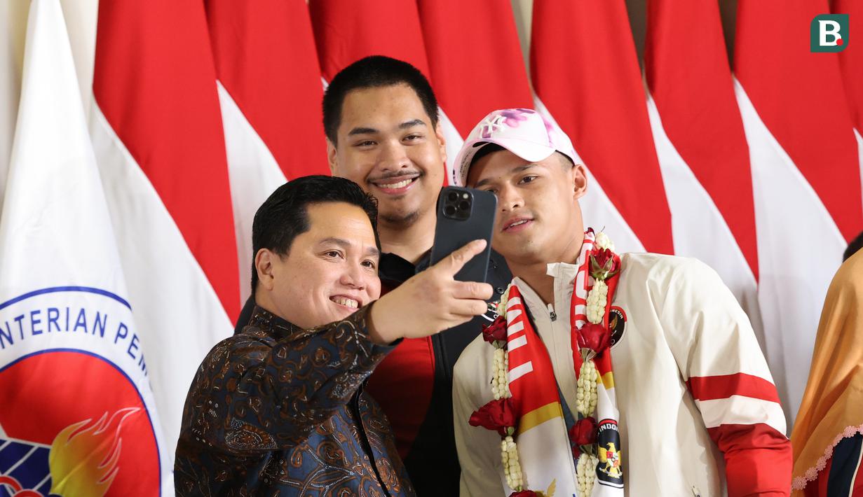 <p>Erick Thohir (kiri) dan&nbsp;Menteri Pemuda dan Olahraga Dito Ariotedjo foto bersama dengan Rizki Juniansyah pada saat di&nbsp;Bandara Internasional Soekarno-Hatta, Tangerang, Selasa (13/8/2024). (Abdul Aziz/Bola.com).</p>