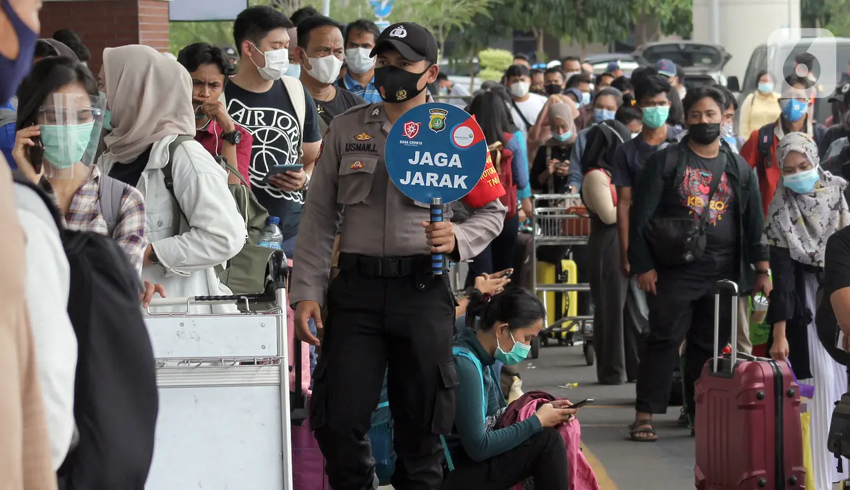 Polisi mengingatkan jaga jarak saat calon penumpang mengntre untuk rapid test antigen di Terminal 2 Bandara Soekarno-Hatta, Tangerang, Banten, Selasa (22/12/2020). Calon penumpang mengaku rata-rata antre hingga tiga jam untuk mendapatkan layanan rapid test antigen. (merdeka.com/Arie Basuki)