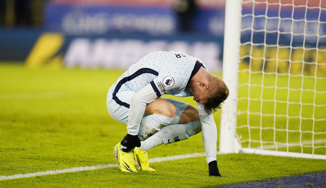 Striker Chelsea, Timo Werner, memegang kakinya yang kesakitan saat melawan Leicester City pada laga Liga Inggris di Stadion King Power, Selasa (19/1/2021). Chelsea takluk dengan skor 2-0. (Tim Keeton/Pool via AP)