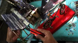 Perajin, Inoe Farhand melakukan finishing pengerjaan pembuatan miniatur jam dari pelepah pisang di Pamulang, Tangerang Selatan, Kamis (10/1). Kerajinan tangan Inoe hasilnya dijual ke sejumlah wiliyah JODETABEK hingga mancanegara. (Merdeka.com/Arie Basuki)