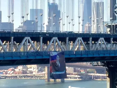 Banner raksasa bergambar Presiden Rusia Vladimir Putin terlihat tergantung di Jembatan Manhattan, New York, Kamis (6/10). Pihak kepolisian New York saat ini tengah mencari pelaku yang menggantungkan banner raksasa itu. (Kathryn Peters/Handout via Reuters)