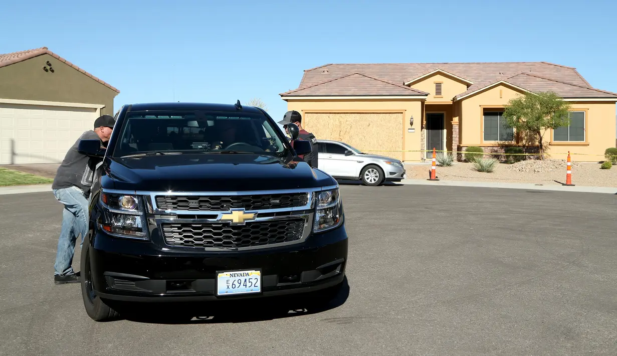 Kepolisian Mesquite berbincang di depan rumah pelaku penembakan Las Vegas, Stephen Paddock, di Nevada, Senin (2/10). Paddock adalah bekas akuntan kaya, yang menikmati masa pensiun yang tenang di komunitas pensiunan Mesquite. (Gabe Ginsberg/AFP)