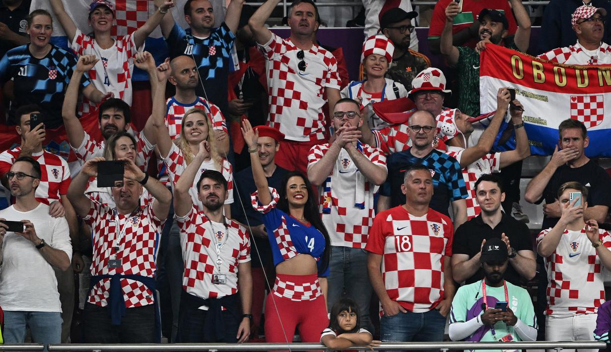 Sejumlah suporter Timnas Kroasia yang hadir di Khalifa International Stadium juga ikut merayakan kemeriahan setelah Kroasia mencatatkan separuh dari kiprah di Piala Dunia selalu berakhir di posisi tiga besar. (AFP/Paul Ellis)