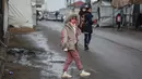 Seorang gadis kecil berjalan menuju sekolah di Deir al-Balah, di Jalur Gaza tengah, pada 10 Desember 2025. Secara bertahap, anak-anak di Gaza mulai kembali ke sekolah. (BASHAR TALEB/AFP)