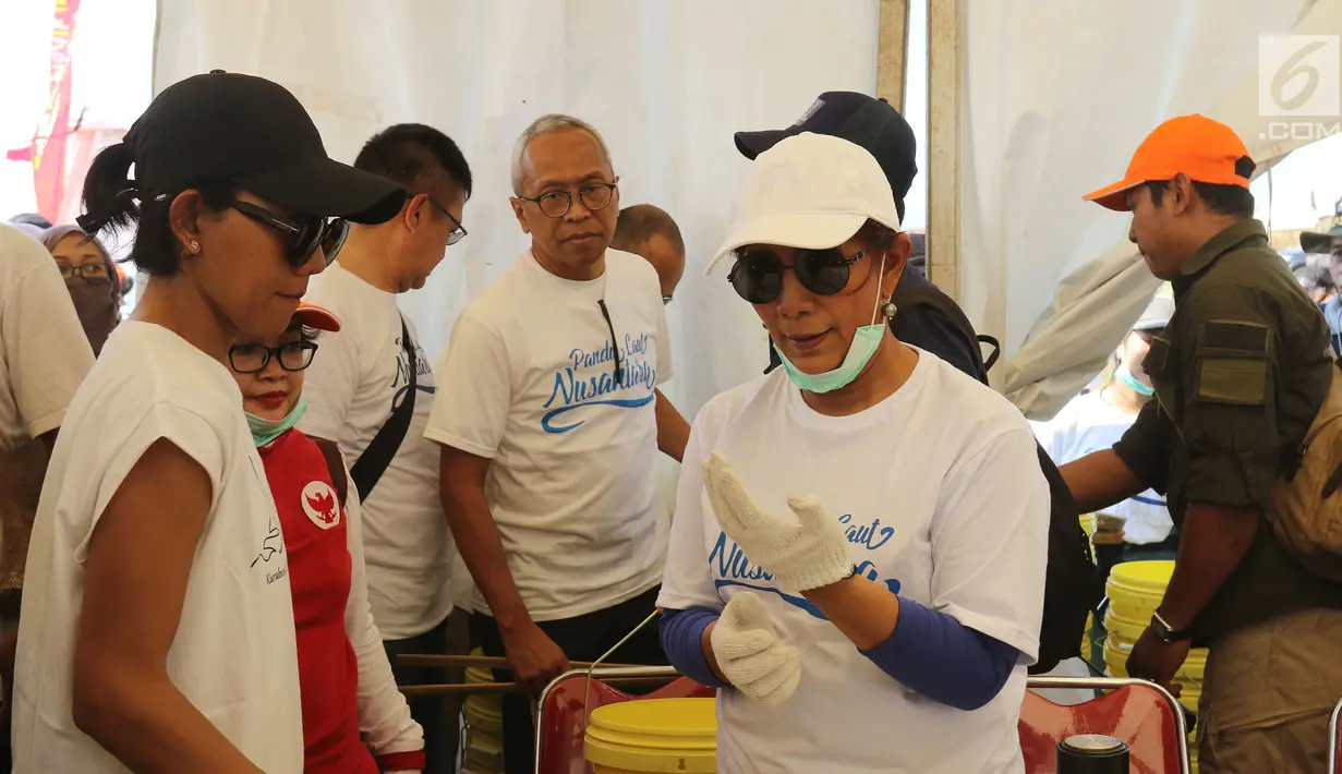 Menteri Kelautan dan Perikanan Susi Pudjiastuti memakai sarung tangan saat akan membersihkan sampah di Pantai Timur Ancol, Jakarta, Minggu (18/8/2019). Gerakan Menghadap Laut 2.0 akan digelar serentak di 74 titik di berbagai daerah di Indonesia. (Liputan6.com/Herman Zakharia)