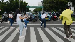 Sejumlah mahasiswa dan mahasiswi menari saat mengampanyekan keselamatan berlalu lintas di Jakarta, Rabu (20/3). Aksi ini mengajak pengendara untuk tertib berlalu lintas dengan #SelamatDijalan. (merdeka.com/Imam Buhori)