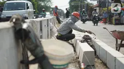 Pekerja menyelesaikan pembuatan separator jalan di kawasan Pasar Minggu, Jakarta Selatan, Rabu (23/10/2019). Pembuatan separator permanen tersebut merupakan bagian dari penataan kawasan Pasar Minggu agar lebih tertata dengan rapi. (Liputan6.com/Immanuel Antonius)