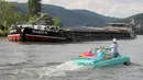 Sebuah mobil amphibi salah satu peserta reli "Amphib 2014" tampak melewati sebuah kapal yang sedang singgah di  sungai Mosel, Jerman, Minggu (3/8/2014)  (AFP PHOTO/Fredrik VON Erichse)