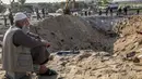 Seorang pria duduk dekat kawah besar bekas serangan udara Israel di Deir al-Balah di Jalur Gaza selatan, Kamis (14/11/2019). Kementerian Kesehatan Gaza mengatakan, 32 warga Palestina, termasuk anak-anak, telah tewas oleh serangan Israel sejak Selasa (12/11) waktu setempat. (SAID KHATIB/AFP)