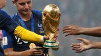 Kiper timnas Prancis, Hugo Lloris memberikan trofi Piala Dunia 2018 kepada rekan setimnya pada perayaan gelar juara pada  laga final di Luzhniki Stadium, Minggu (15/7). Prancis membekuk Kroasia dengan skor akhir 4-2. (AP Photo/Natacha Pisarenko)