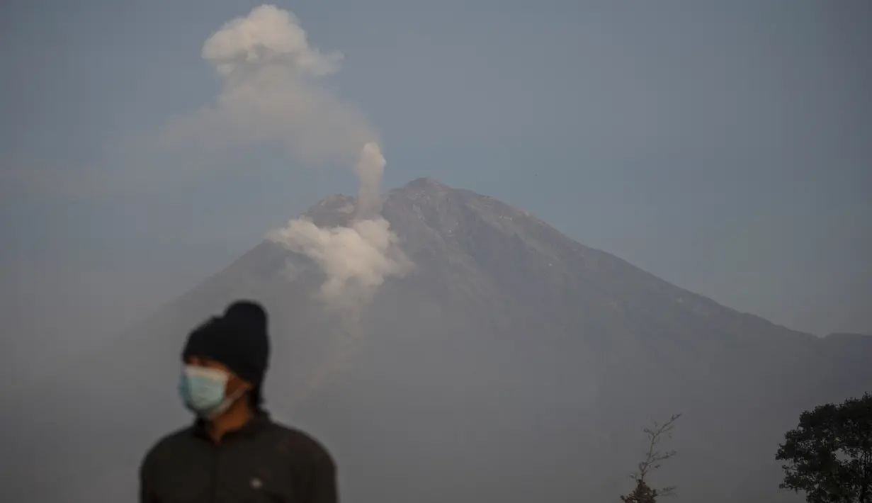 Asap mengepul dari Gunung Semeru di Lumajang (5/12/2022). Gunung Semeru meletus pada tanggal 4 Desember memuntahkan awan abu panas setinggi satu mil dan sungai lava di sisinya sambil memicu evakuasi hampir 2.000 orang tepat satu tahun setelah letusan besar terakhirnya menewaskan puluhan orang. (AFP/Juni Kriswanto)