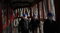 Para pekerja yang mengenakan pelindung wajah dan masker berjalan dalam hotel gelembung Paralimpiade Musim Dingin 2022 di Distrik Yanqing, Beijing, China, 8 Maret 2022. China alami lonjakan baru kasus COVID-19 meski pendekatan "tanpa toleransi" yang ketat untuk menangani wabah. (AP Photo/Andy Wong)
