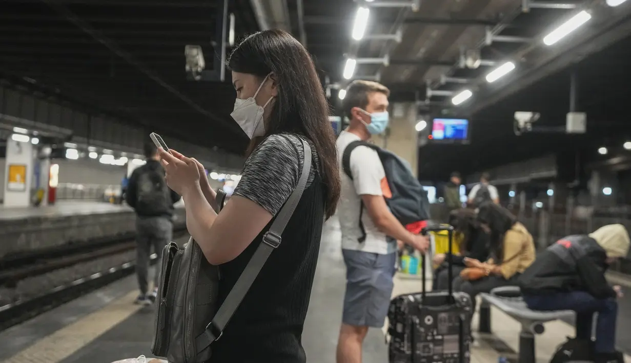 Seorang perempuan yang mengenakan masker menunggu di stasiun kereta api di Paris, Prancis, Kamis (30/6/2022). Kasus virus corona covid-19 meningkat dengan cepat di Prancis dan negara-negara Eropa lainnya setelah pembatasan COVID-19 dicabut pada musim semi. (AP Photo/Michel Euler)