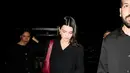 Kendall Jenner tampil minimalis dengan cardigan dan rok mini hitam. Ia jinjing tas Chanel merah dan flatshoes dual tone [Chanel]