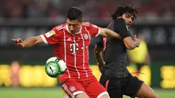 Striker Bayern Munchen, Robert Lewandowski, berebut bola dengan gelandang Arsenal, Mohamed Elneny pada laga ICC 2017, di Stadion Shanghai, Rabu (19/7/2017). Arsenal menang adu penalti dengan skor 3-2 atas Bayern Munchen. (AFP/Johannes Eisele)