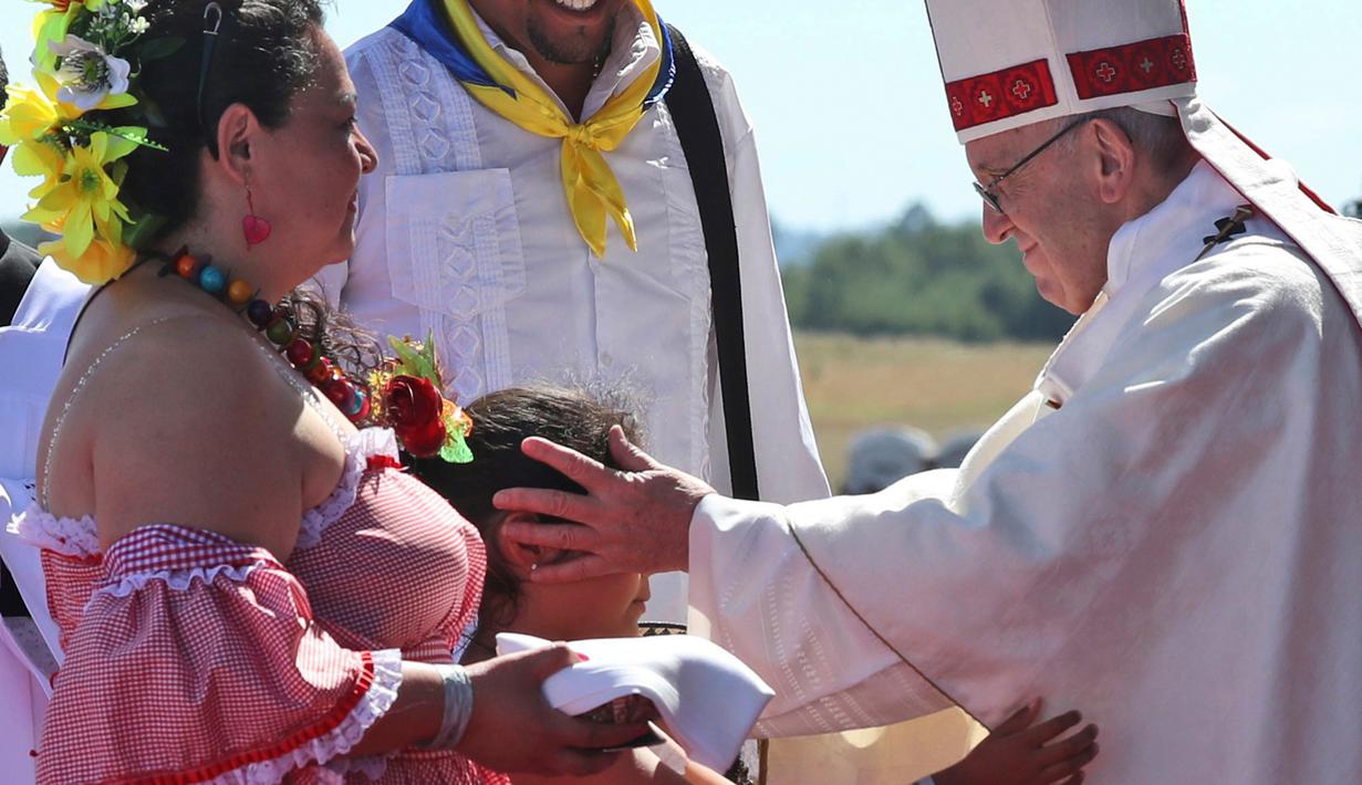 Seorang anak mengulurkan tangan untuk memeluk Paus Fransiskus dalam acara Misa di Pangkalan Udara Maquehue, di Temuco, Chili (17/1). (AP Photo/Alessandra Tarantino)