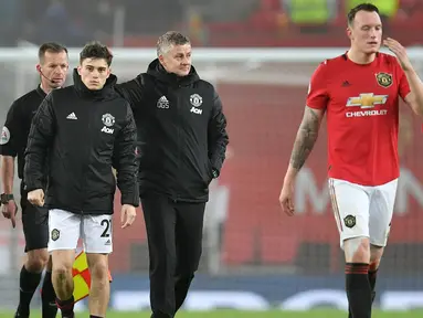 Manajer Manchester United, Ole Gunnar Solskjaer bersama timnya, Daniel James, Phil Jones dan Aaron Wan-Bissaka meninggalkan lapangan setelah laga lanjutan Liga Inggris kontra Burnley di Old Trafford, Rabu (23/1/2020). MU tidak berdaya di kandang sendiri usai takluk 0-2 dari Burnley. (Paul ELLIS/AFP)