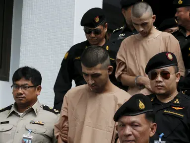 Dua tersangka pemboman Yusufu Mieraili dan Bilal Mohammed berjalan dikawal petugas saat meninggalkan Pengadilan militer (24/11). Pengadilan Thailand telah mendakwa dua orang yang dituduh melakukan serangan bom di Bangkok. (REUTERS /Chaiwat Subprasom)