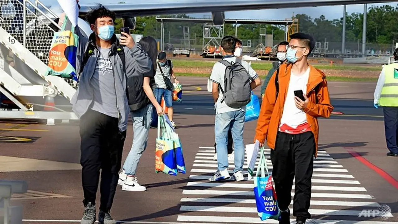Mahasiswa asing turun dari penerbangan internasional di Bandara Darwin. Ini merupakan ketibaan pertama sejak penutupan perbatasan Australia pada Maret 2020.
