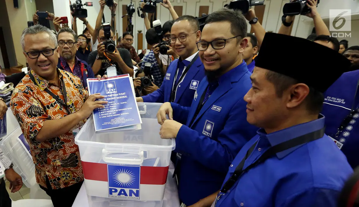 Wakil Ketua Umum PAN Hanafi Rais didampingi Sekjen Eddy Soeparno menyerahkan berkas pendaftaran partai kepada Ketua KPU Arief Budiman di KPU Pusat, Jakarta, Jumat (13/10). PAN secara resmi mendaftar sebagai peserta Pemilu 2019. (Liputan6.com/Johan Tallo)