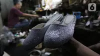 Perajin memperlihatkan sepasang sandal yang selesai dibuat di Jakarta, Jumat (17/1/2020). Pengamat menilai perlambatan pertumbuhan kredit usaha mikro, kecil, dan menengah (UMKM) berpotensi tidak akan berlanjut pada tahun ini. (Liputan6.com/Angga Yuniar)