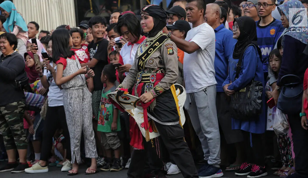Anggota polisi wanita (polwan) melakukan atraksi saat pertunjukan Tari Reog Ponorogo di area car free day kawasan Bundaran Hotel Indonesia (HI), Jakarta, Minggu (28/4/2019). Kegiatan untuk memperingati Hari Kartini tersebut turut diramaikan oleh sejumlah polwan. (Liputan6.com/Faizal Fanani)