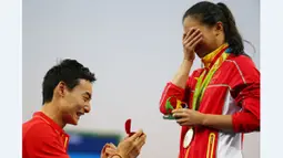 Peloncat indah China, Qin Kai (kiri), melamar kekasihnya yang juga peloncat indah China, He Zi, seusai acara pengalungan medali Olimpiade Rio 2016 di Maria Lenk Aquatics Centre, Rio de Janeiro, Brasil, (14/8/2016). (Reuters/Michael Dalder)