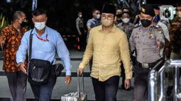 Bupati Bangkalan Abdul Latif Amin Imron membawa koper dan dikawal saat tiba di Gedung Komisi Pemberantasan Korupsi (KPK), Jakarta, Rabu (7/12/2022). KPK menangkap Bupati Bangkalan Abdul Latif Amin Imron sebagai tersangka kasus suap lelang jabatan di Pemerintahan Kabupaten Bangkalan, Jawa Timur. Total kekayaan yang dimiliki Abdul Latif sebanyak Rp 9,9 miliar. (Liputan6.com/Johan Tallo)