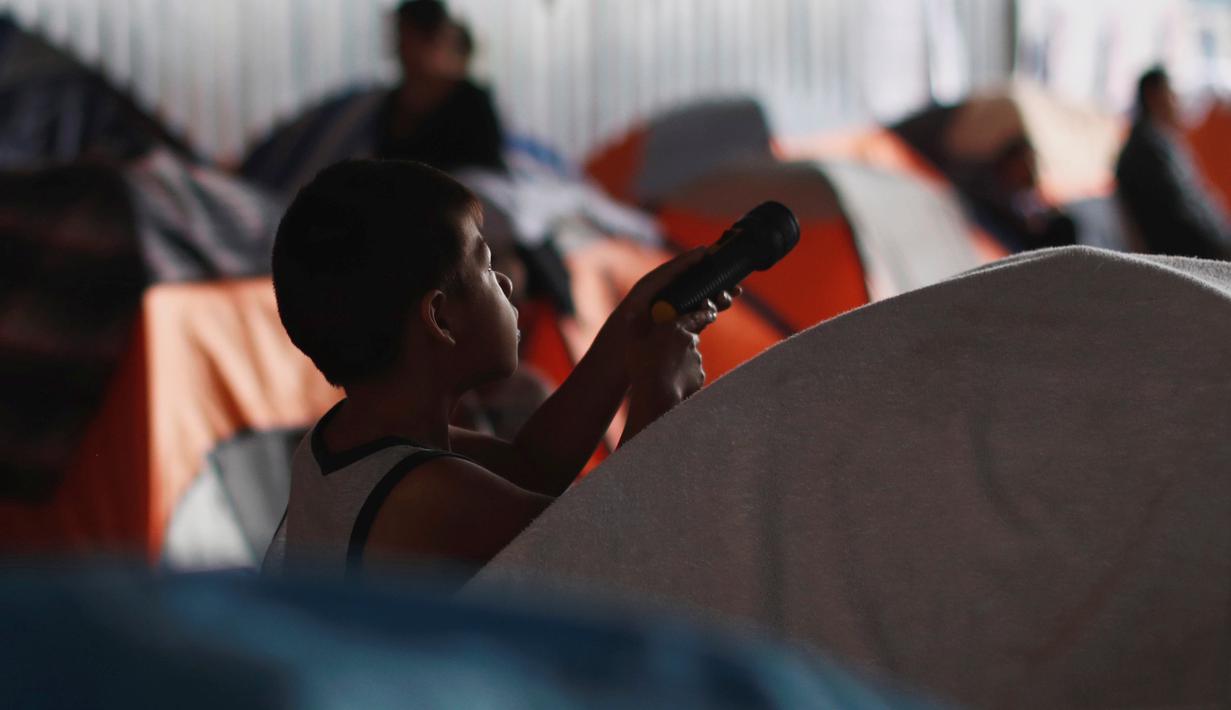 Seorang anak imigran bermain di luar tenda tempat penampungan di Tijuana, Meksiko 6 April 2019. Rombongan migran Amerika Tengah mencapai kota perbatasan antara Meksiko dan AS tersebut  untuk mencari suaka akibat kekerasan, pembunuhan dan kemiskinan yang mengancam mereka. (REUTERS/Carlos Jasso)