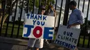 <p>Hugh Kieve (10) memegang papan bertuliskan 'Terima Kasih Joe' bersama saudara perempuannya Margot dan ayahnya David Kieve di sepanjang Pennsylvania Avenue di depan Gedung Putih, Minggu (21/7/2024). (SAMUEL CORUM / AFP)</p>