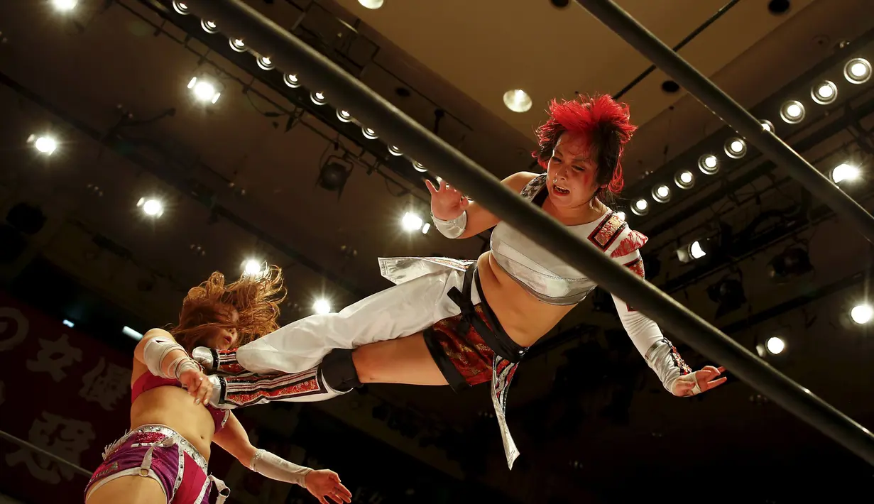 Pegulat Act Yasukawa (kanan) saat beraksi melawan Kairi Hojo pada gelaran gulat wanita profesional di Jepang , (23/12/2015). Mereka melakukan gerakan melompat, membanting dan gerakan brutal lainnya dalam mengikuti kompetisi ini. (REUTERS / Thomas Peter)