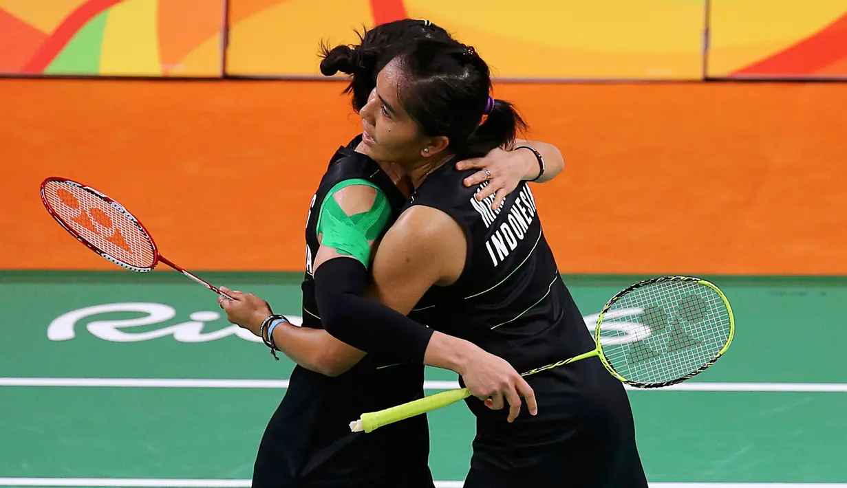 Pebulutangkis ganda putri Indonesia, Nitya Krishinda Maheswari dan Greysia Polii berpelukan usai mengalahkan ganda putri Inggris Heather Olver dan Lauren Smith pada Olimpiade 2016 di Rio de Janeiro, Brasil, (13/8). (REUTERS/Marcelo del Pozo)