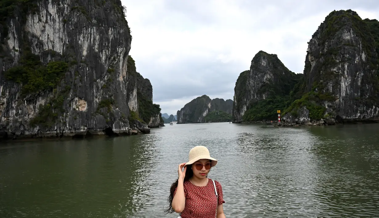 Wisatawan domestik berpose untuk foto di atas kapal di tengah Ha Long Bay, Quang Ninh, Vietnam, (16/5/2020). Seiring dengan meredanya virus corona, Ha Long Bay kawasan yang menjadi situs warisan dunia UNESCO kembali didatangi ratusan wisatawan. (AFP/Manan Vatsyayana)