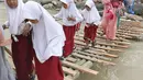 Siswa melintasi jembatan darurat berbahan bambu di Kampung Ciasahan, Desa Sukamaju, Kabupaten Bogor, Kamis (6/2/2020). Pembangunan kembali jembatan Ciasahan yang ambruk akibat banjir bandang pada Rabu (1/1) itu diharapkan mampu memulihkan aktivitas dan perekonomian warga. (merdeka.com/Arie Basuki)