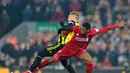 Duel Georginio Wijnaldum dan Gerard Deulefou pada laga lanjutan Premier League yang berlangsung di stadion Anfield, Liverpool, Kamis (28/2). Liverpool menang 5-0 atas Watford. (AFP/Anthony Devlin)