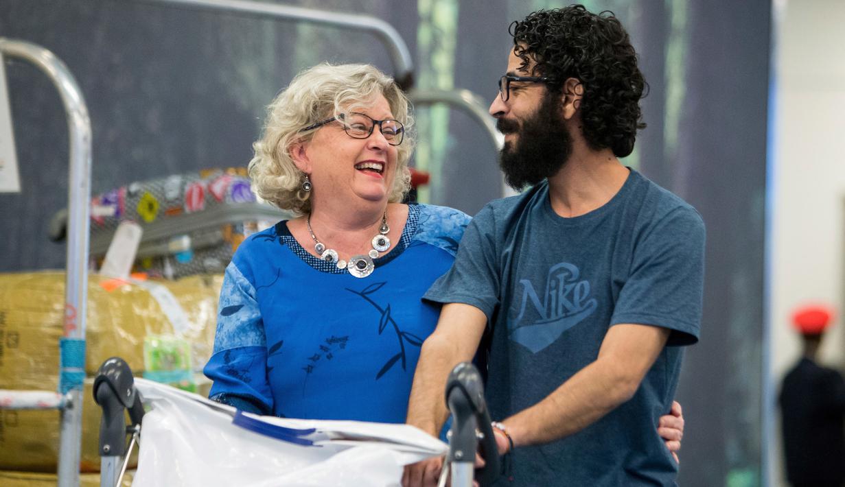 Pria Suriah, Hassan al-Kontar dan sukarelawan Canada Caring Society  tiba di bandara Vancouver setelah terbang dari Kuala Lumpur , Senin (26/11). Dua organisasi mensponsori Kontar datang ke Kanada sebagai pengungsi. (Ben Nelms/The Canadian Press via AP)