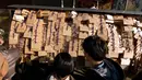 Pelajar melihat papan Ema berisi harapan di Kuil Yushima Tenmangu, Tokyo, Jepang, (7/1). Para siswa dan orang tua di Tokyo ramai-ramai mengunjungi Kuil Yushima Tenmangu untuk berdoa sebelum ujian sekolah dimulai. (AFP Photo/Kazuhiro Nogi)
